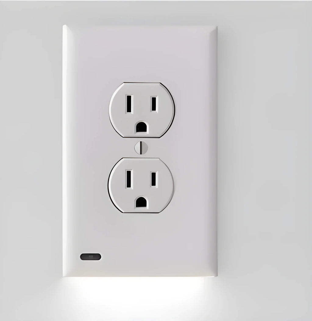 White plug-in socket induction night light installed in a UK wall socket, showing a soft glow from the integrated LEDs.
