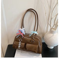 Retro-style PU women's handbag with pillow shape in black, shown with ribbon pendant.