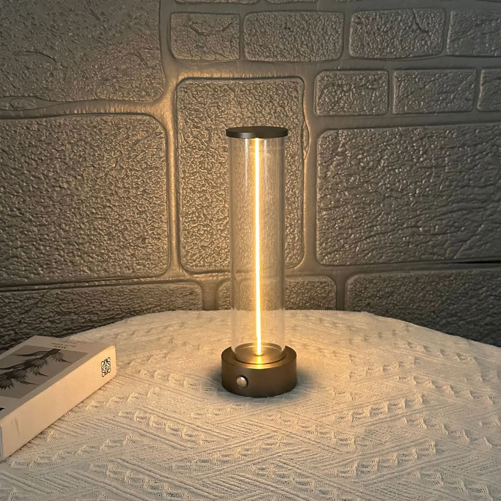 Slim modern glass LED bar night light with magnetic base on a desk surface.