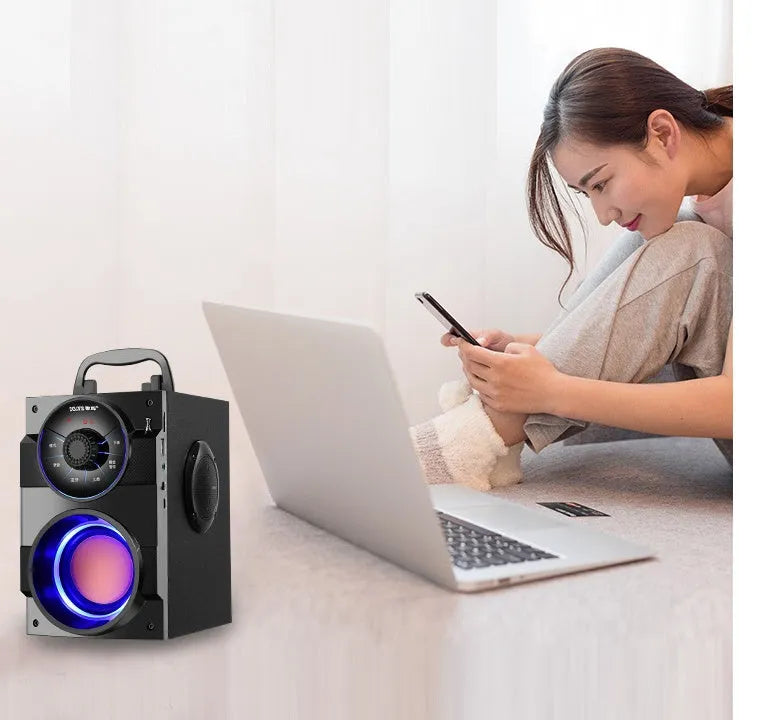 Black portable mini audio system with subwoofer and a 1.2m connection cable on a desk.