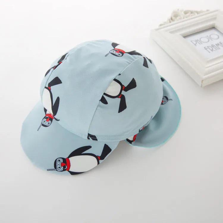 Boy's penguin print long sleeve swimsuit two-piece set with matching swim cap.