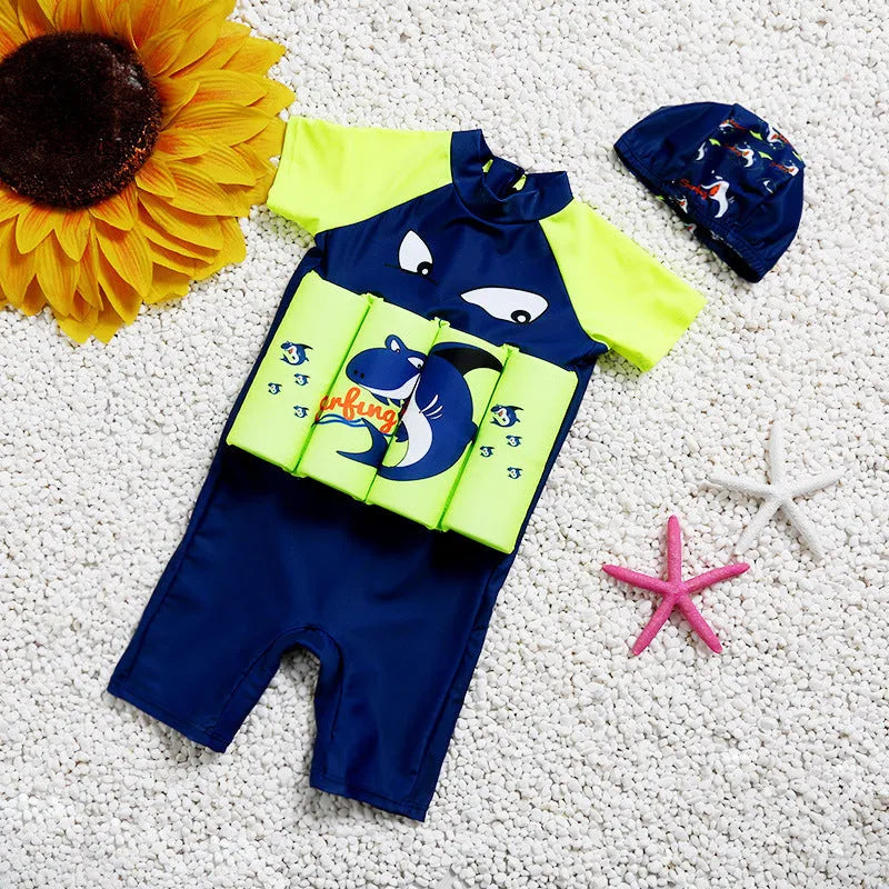 Child in a blue shark print buoyancy swimsuit floating in a swimming pool.
