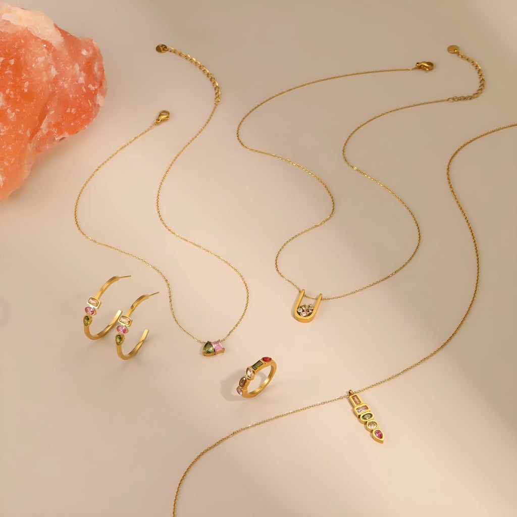 Geometric gold-plated jewellery set with colour zircon stones, showing necklace, ring, and earrings.