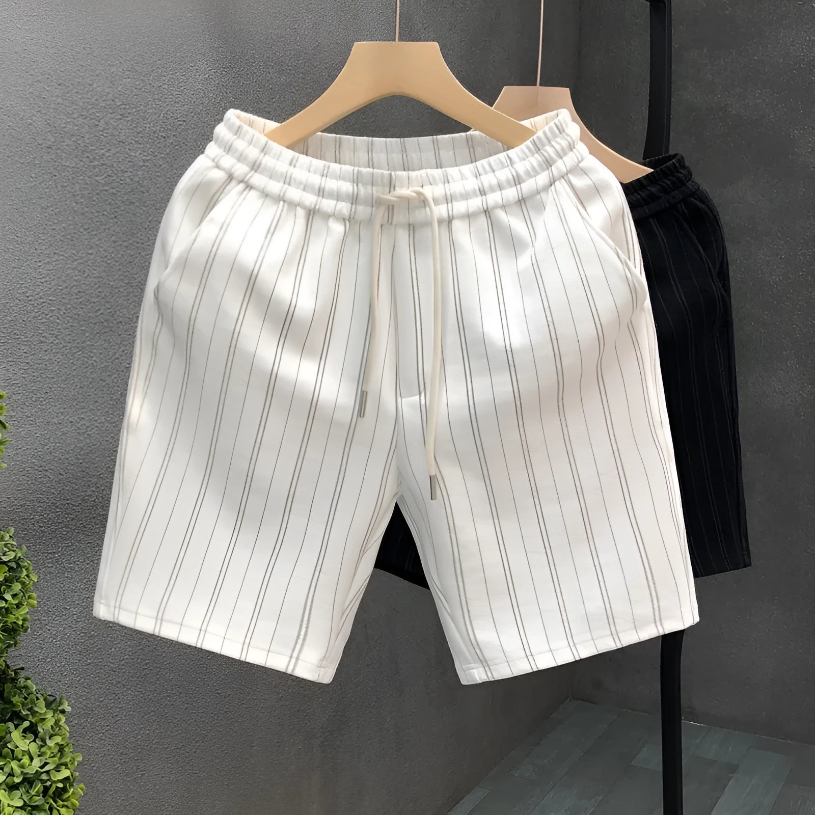 Men's black and white striped casual polyester shorts with an elastic waistband.