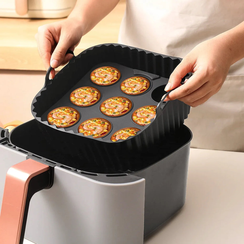 Black silicone square baking tray set for air fryer, 4 pieces on a light background