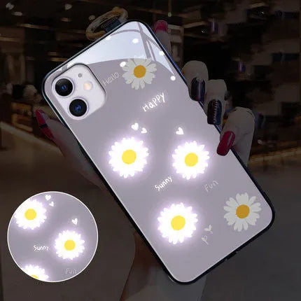 White iPhone case with painted purple daisy design and illuminated multi-colour LED lights around the edges.