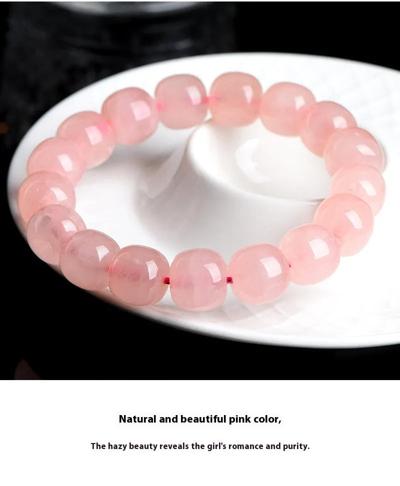 Pink natural crystal bracelet with 8x10mm barrel-shaped beads on a cord.