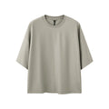 Man wearing a loose-fit Sand Grey short sleeve t-shirt made from cotton-polyester blend.