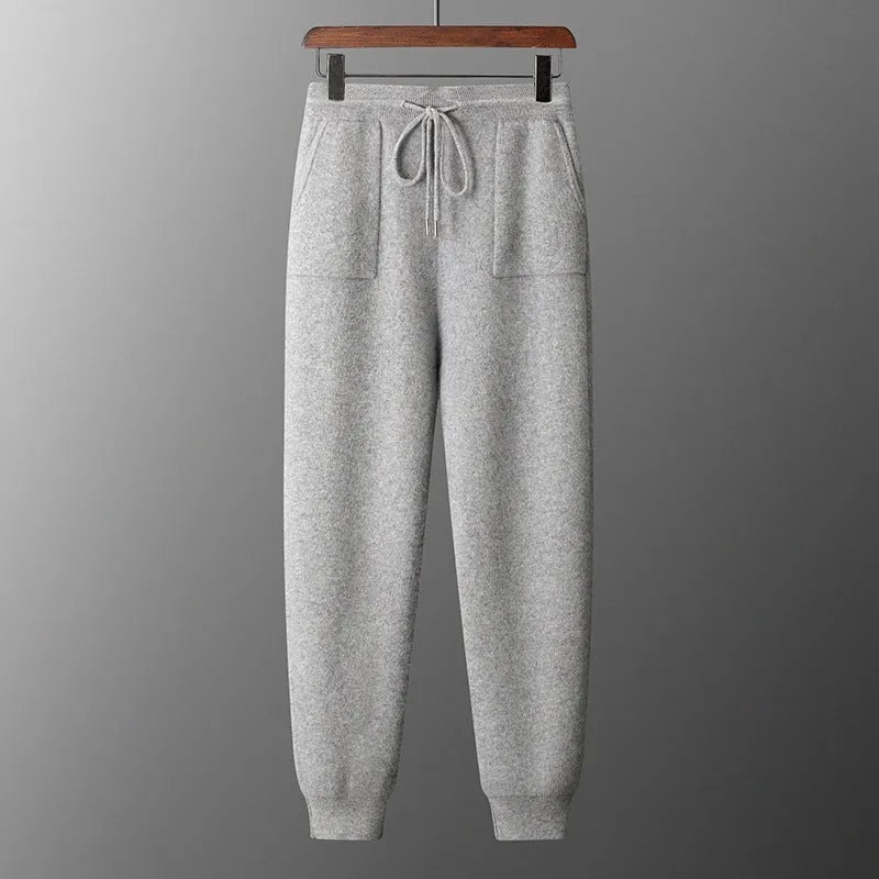 Men's dark grey cashmere hoodie and matching trousers laid out as a complete casual set.