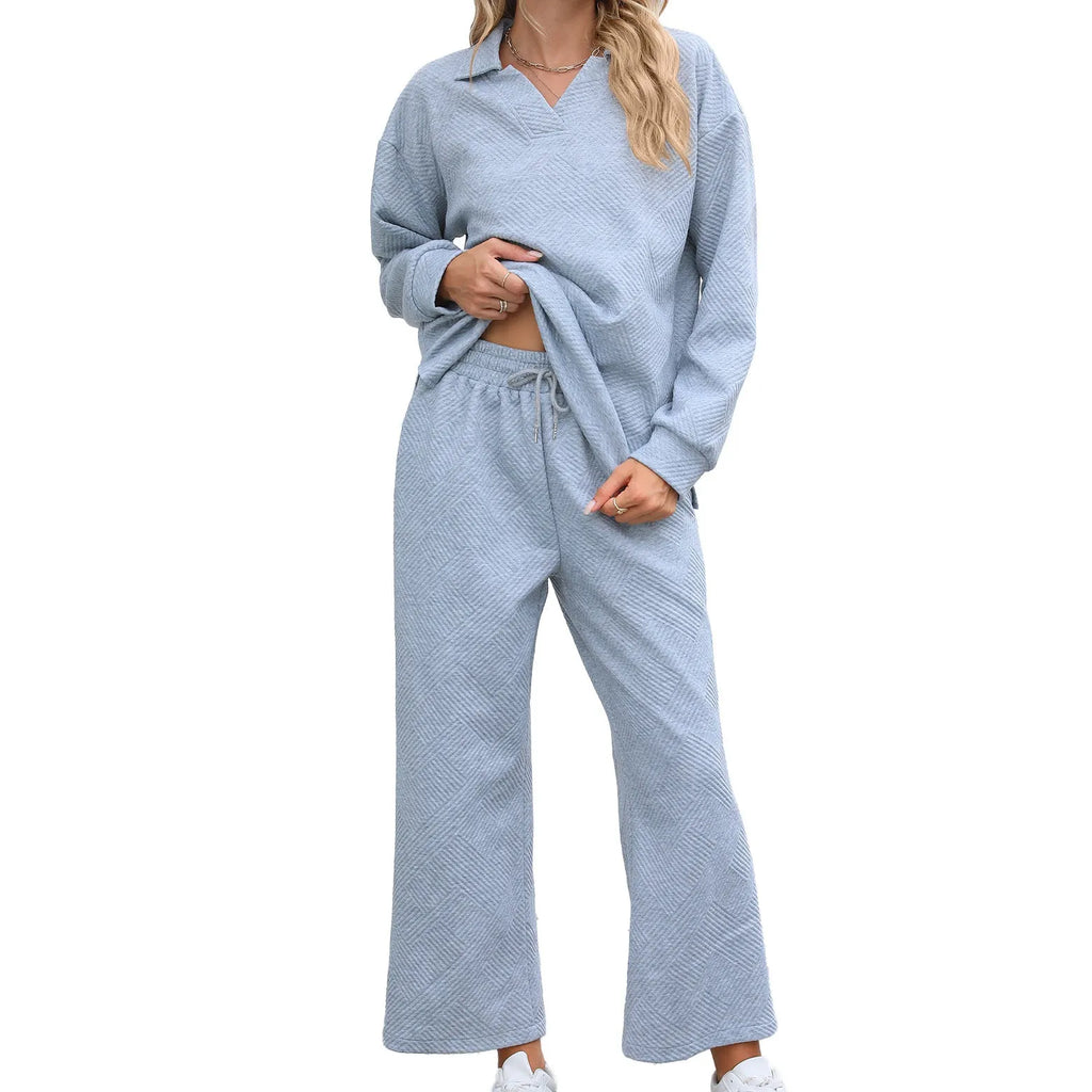 Women's solid colour knitted lapel top and elastic waist cropped trouser suit set laid flat.