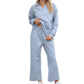 Women's black knitted rayon suit with lapel sweater and elastic waist cropped trousers on a hanger.