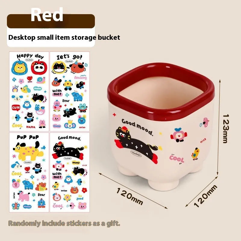 Cartoon-style plastic desktop organiser with grid compartments and red or brown stickers.