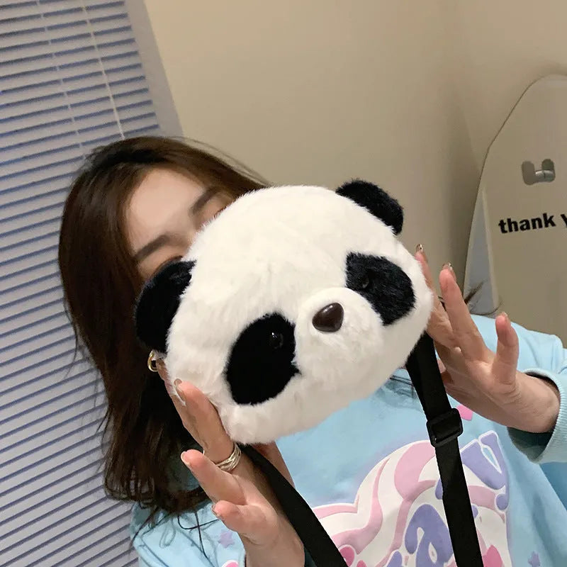 Soft cylindrical plush crossbody bag with panda head design, showing front sandwich pocket.