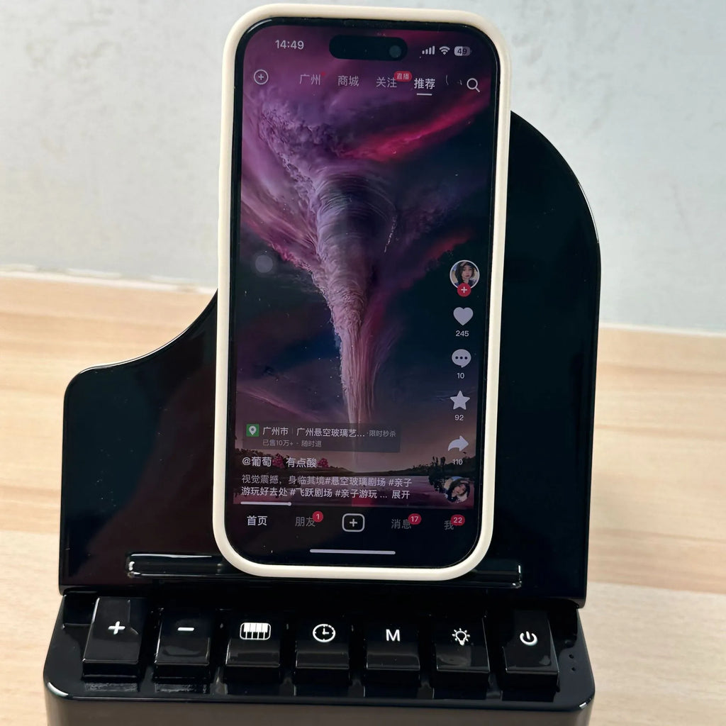Black multi-function Bluetooth speaker wireless charger and phone holder on a desk