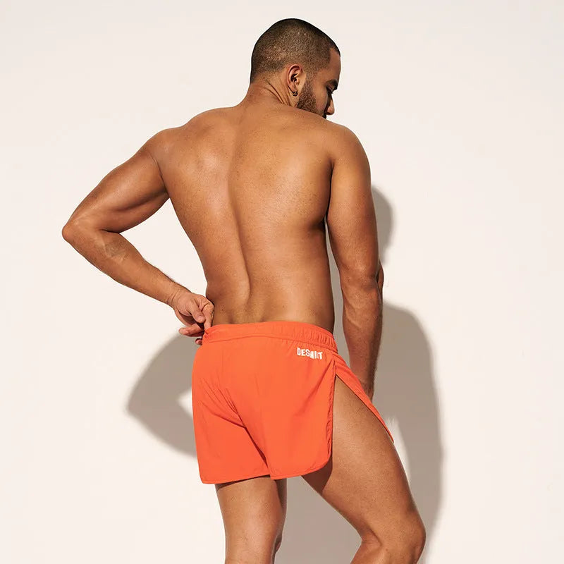 Men's loose beach trousers in polyester with micro elasticity available in black, fluorescent green, and orange red colours