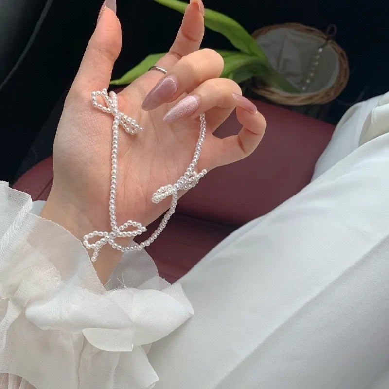 White bow pearl necklace with geometric clasp on woman at clavicle length