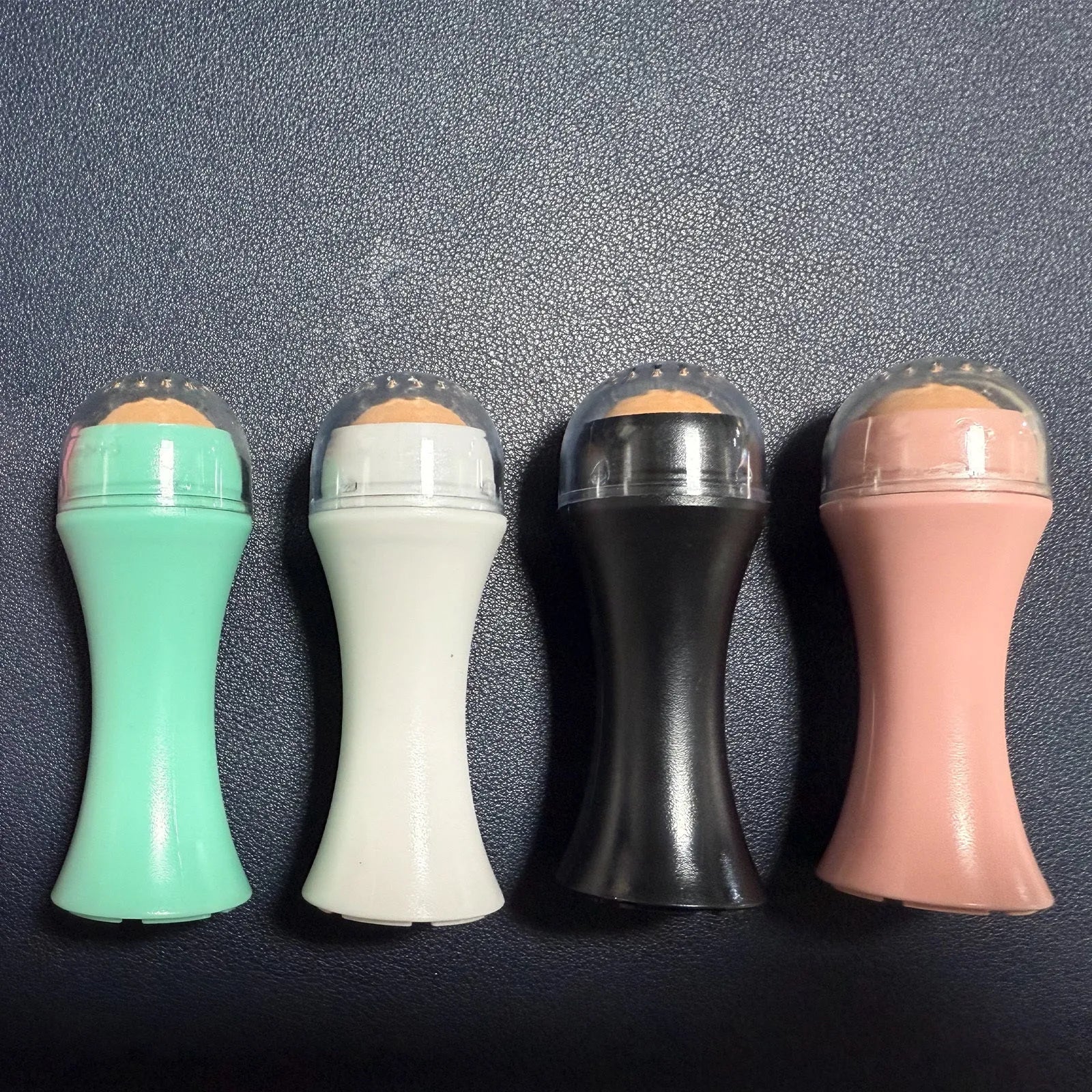 Volcanic stone oil control roller in black, green, pink or white for reusable facial skincare.