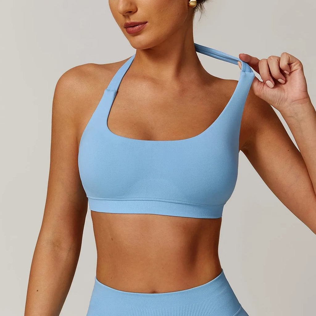 Women's black halter neck sports bra with removable padding for yoga and low-impact workout.