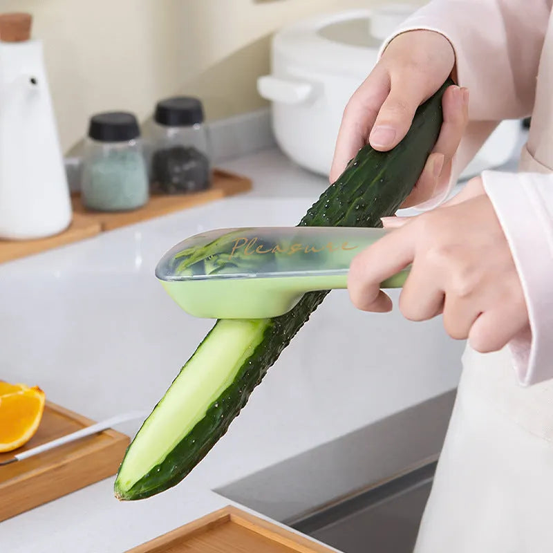 Green fruit and vegetable peeler with a stainless steel blade, plastic handle, and a separate white storage tube.