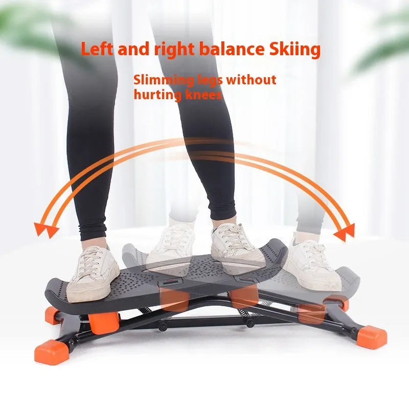 Black mini indoor fitness skiing machine with elastic hand straps on a home floor.