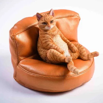Small lazy cat model ornament with sofa on a car dashboard, approximately 7.5cm high.