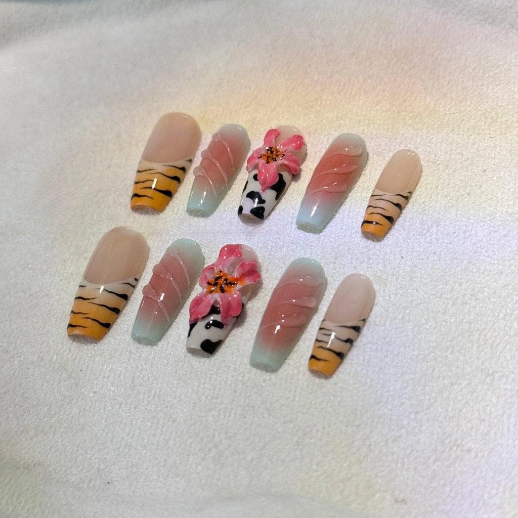 Hand-carved false nails with zebra pattern and lily designs in sizes XS through L