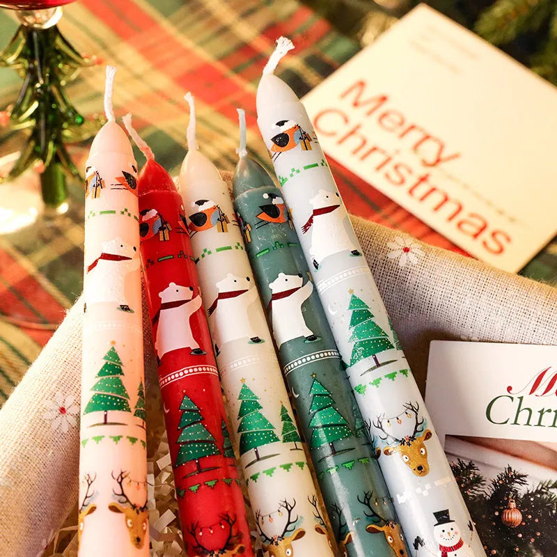 Cylindrical Christmas printed paraffin candle in bright red, 2.2 x 25 cm, on a wooden table