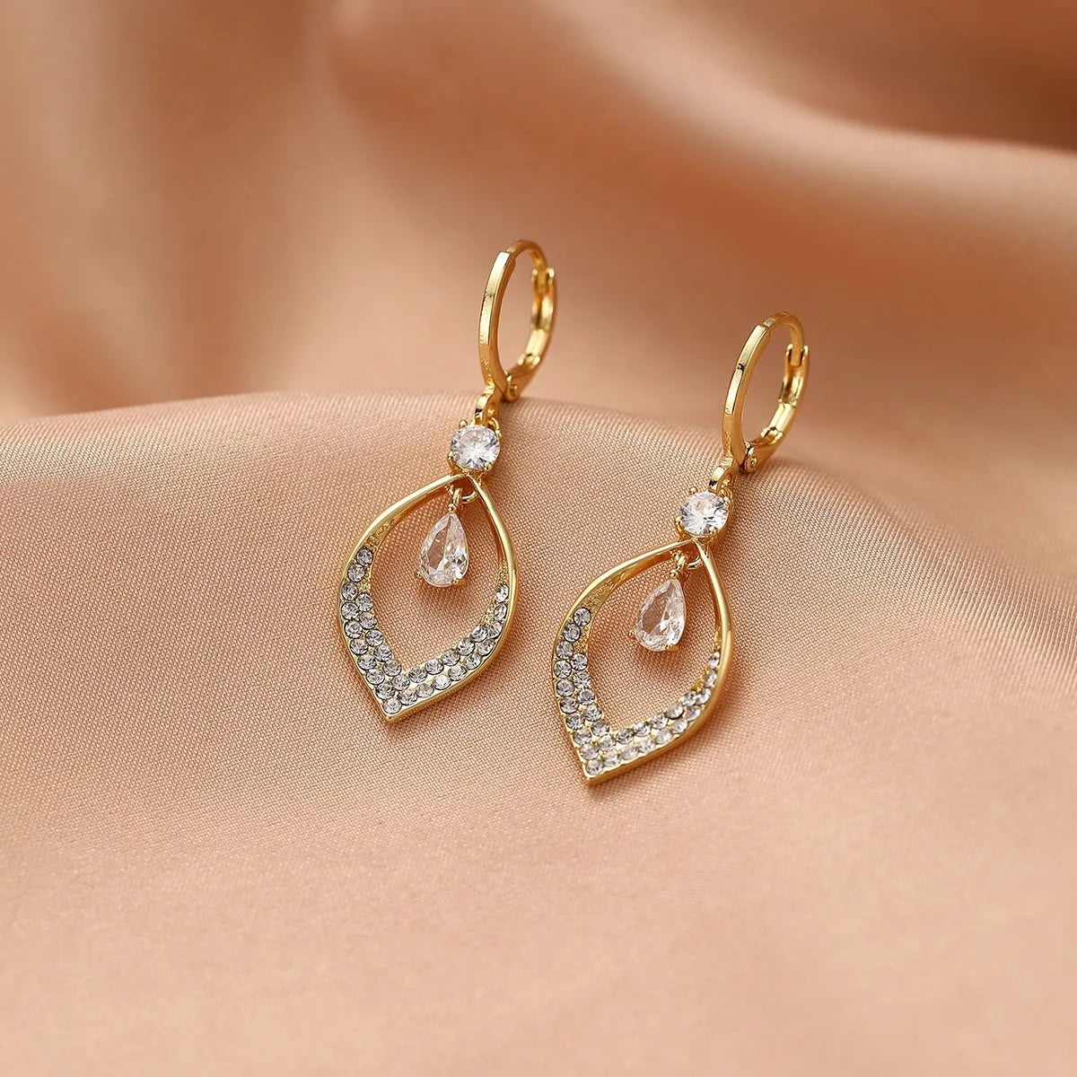 A pair of women's zircon water drop tassel earrings with gold-coloured buckles on a white background.
