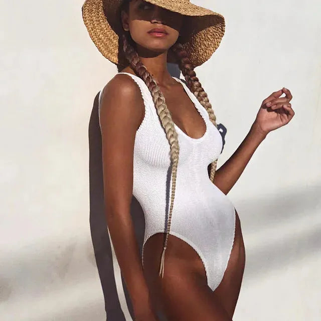 Solid colour women's one-piece swimsuit in seersucker fabric with a backless and sleeveless design.