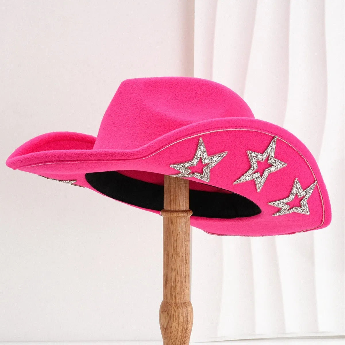 Beige woolen felt western style top hat with a conical crown and a silver hexagonal star decoration on the front.