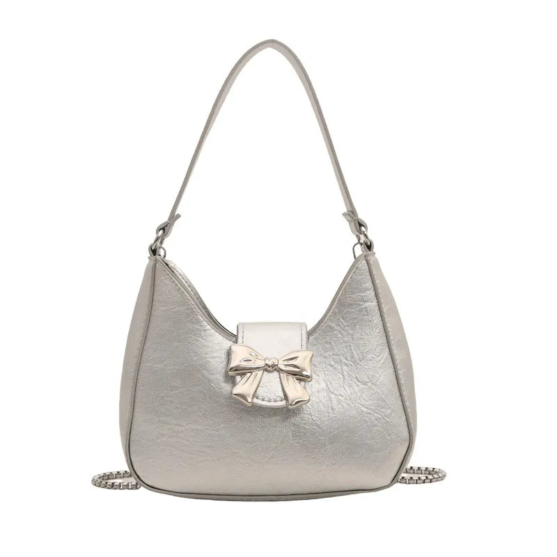 Bow underarm bag in textured PU with one-shoulder strap, dumpling shape and sandwich pocket, shown in black, pink, silver or white