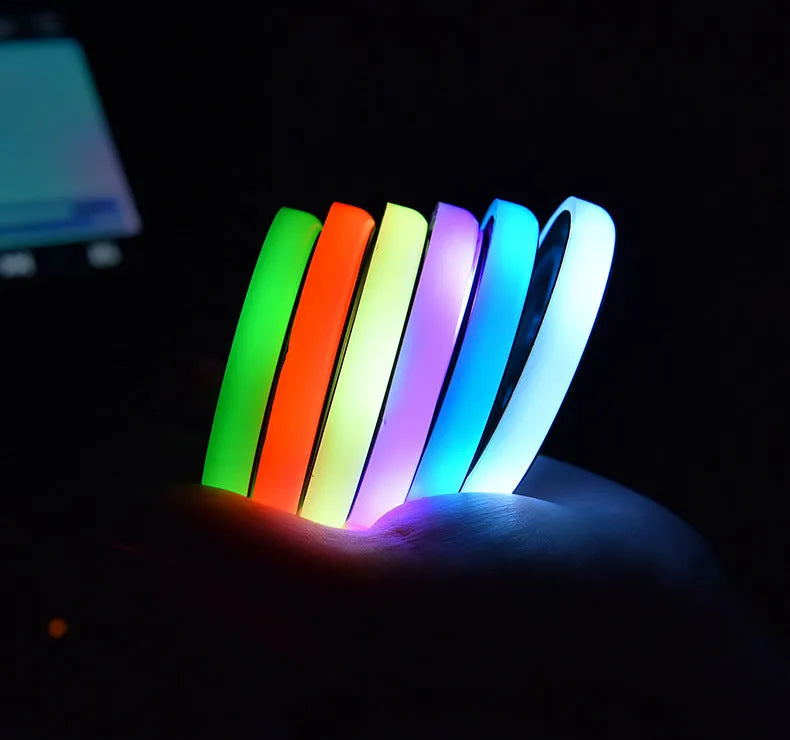 Colourful LED light-up car cup holder coaster with USB cable on a car centre console.