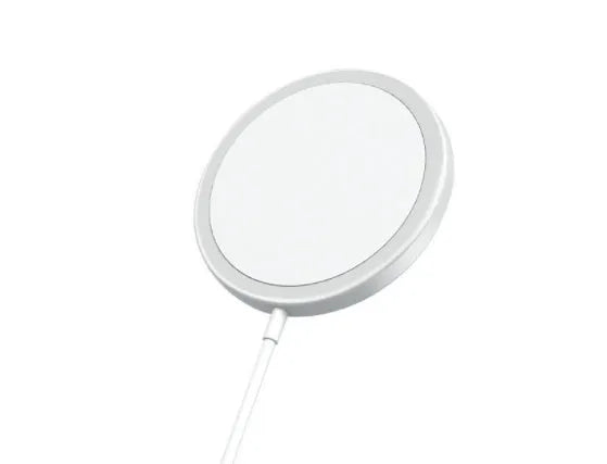 Silver metal Magsafe magnetic wireless charger for Apple iPhone on a desk.