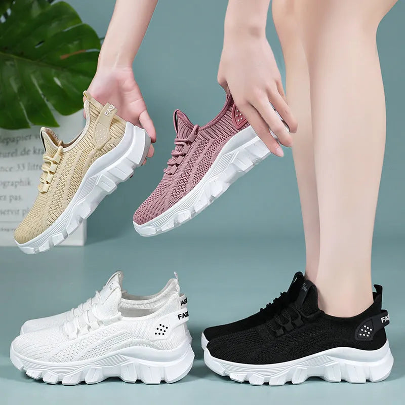 Women's white Flyknit running sneakers with a round toe and flat PVC sole, shown with lace-up front.
