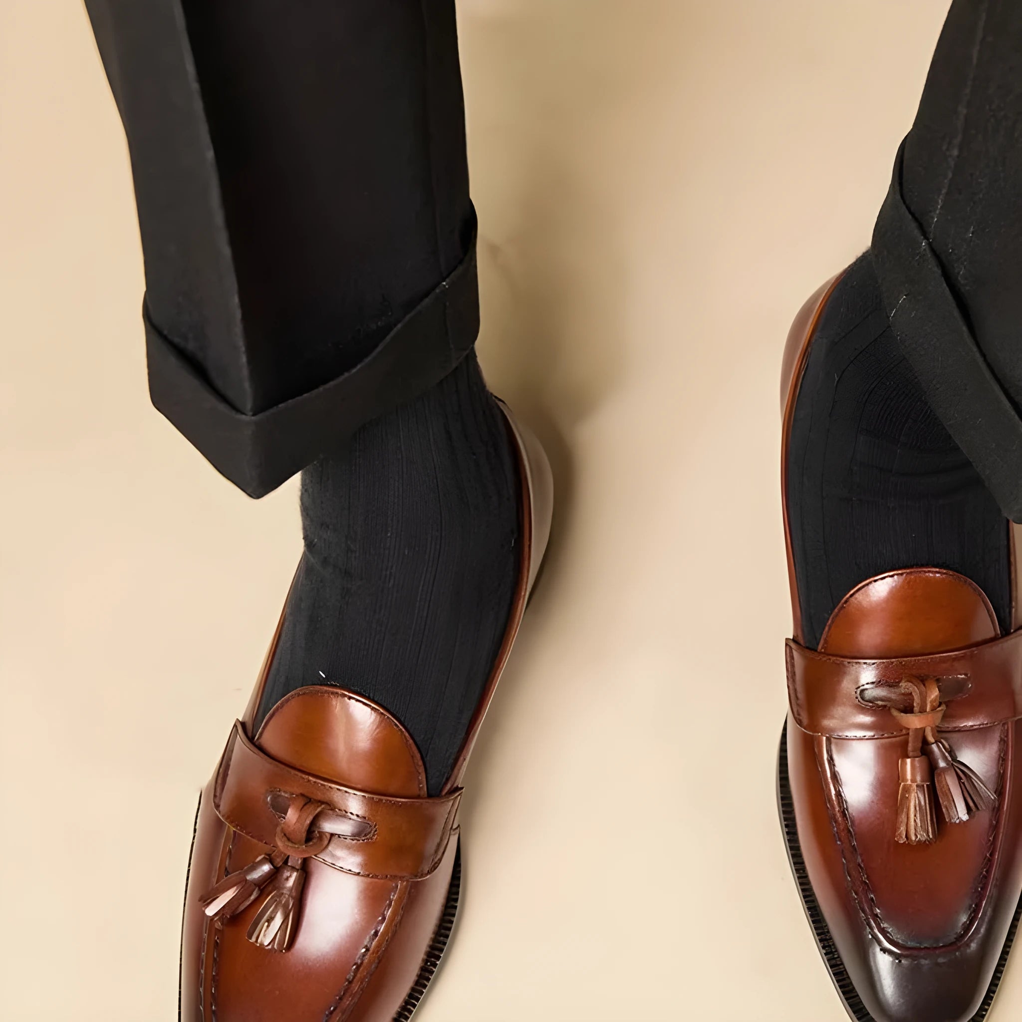 Men's black genuine leather tassel loafers with a polished finish and rubber sole.