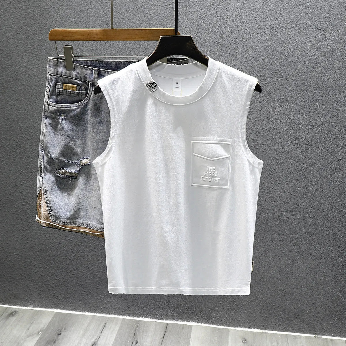 A man's solid black loose-fit cotton sleeveless T-shirt with a straight hem, laid flat.