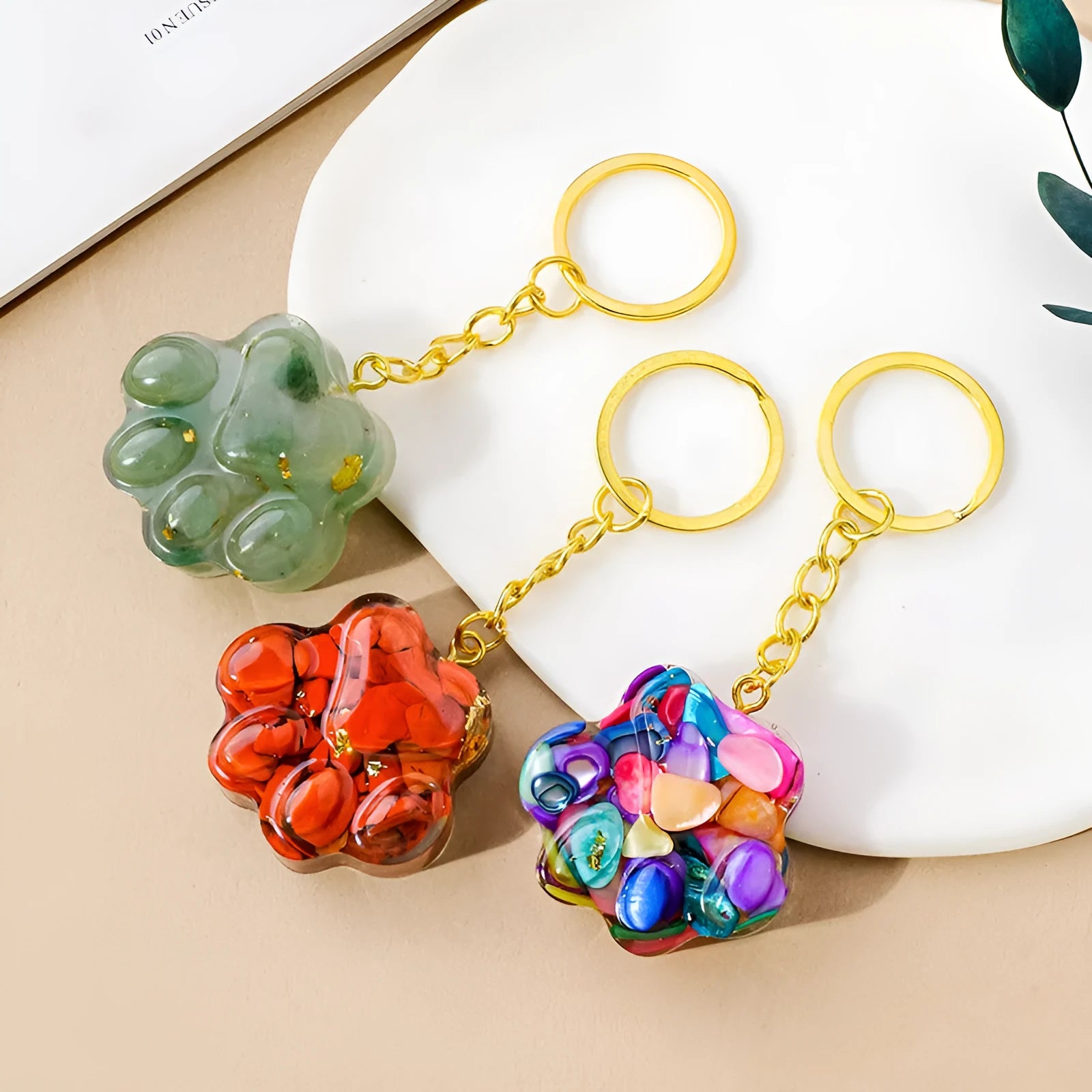 Hand-carved natural crystal cat's paw keychain pendant on a metal ring, showing unique gemstone colour.