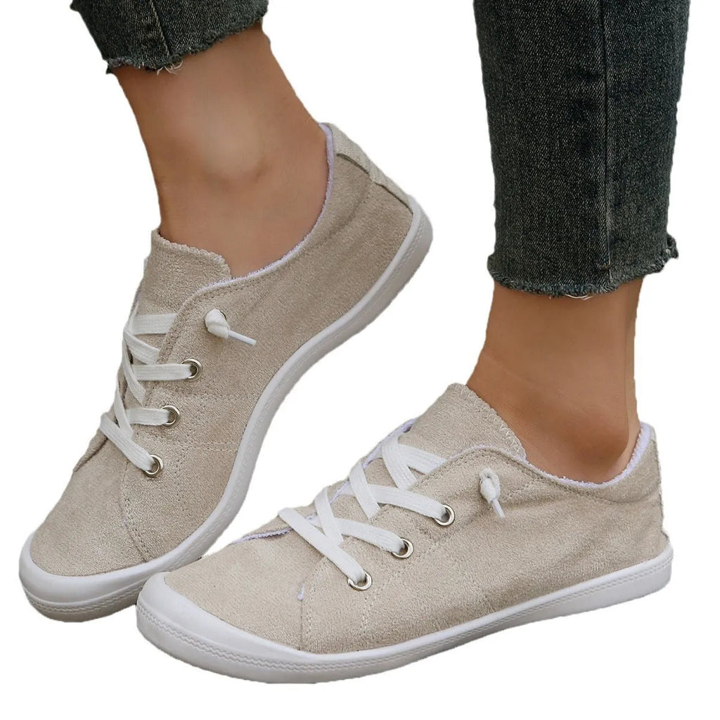 Women's beige low-top fabric casual sneakers with a rubber sole on a neutral background.