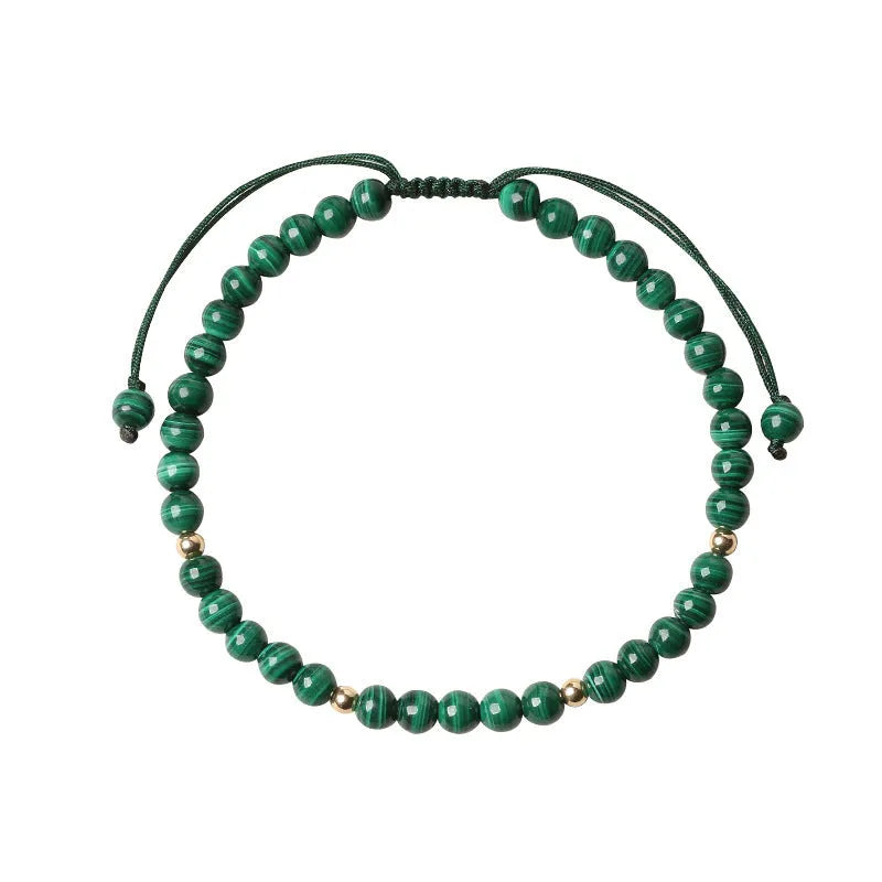 Women's malachite and gold bead bracelet with animal zodiac charm on woven strap.