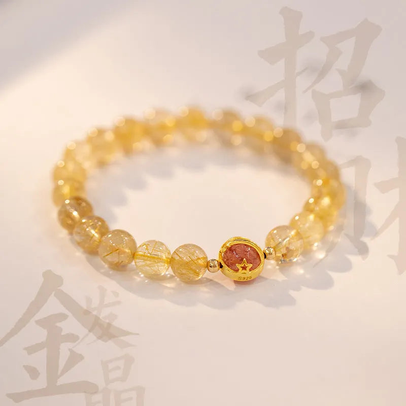Citrine gold rutilated quartz crystal bracelet with diamond-cut beads on a wrist.