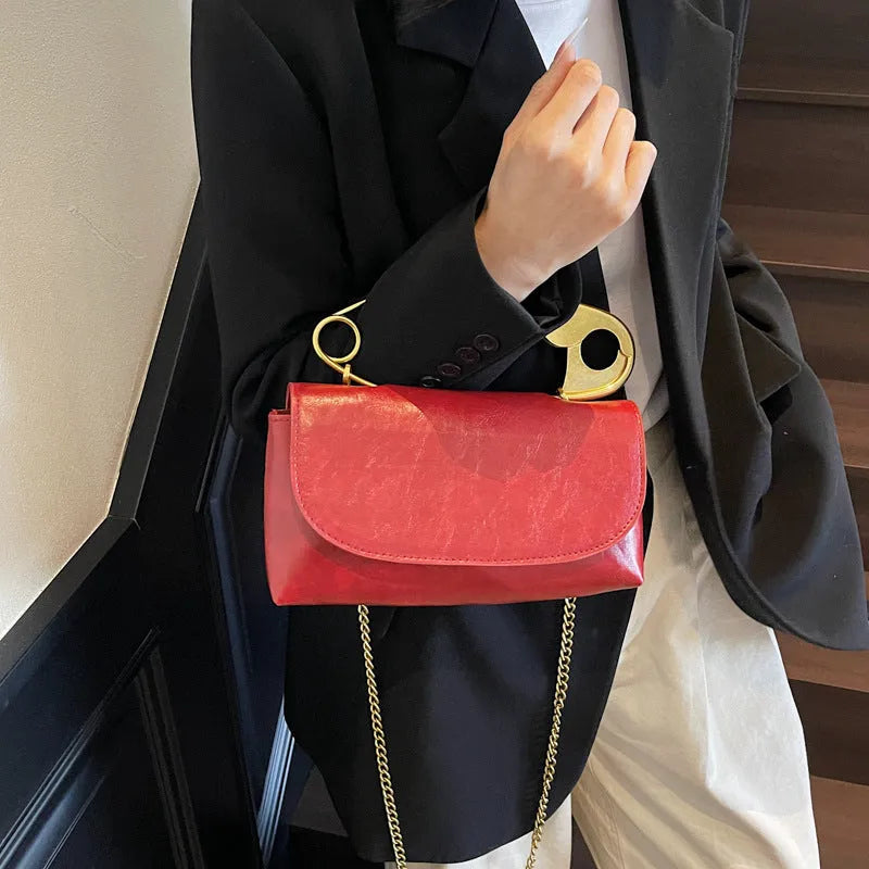 Creative personality paper clip shoulder handbag in PU leather with sandwich pocket and file bag interior.