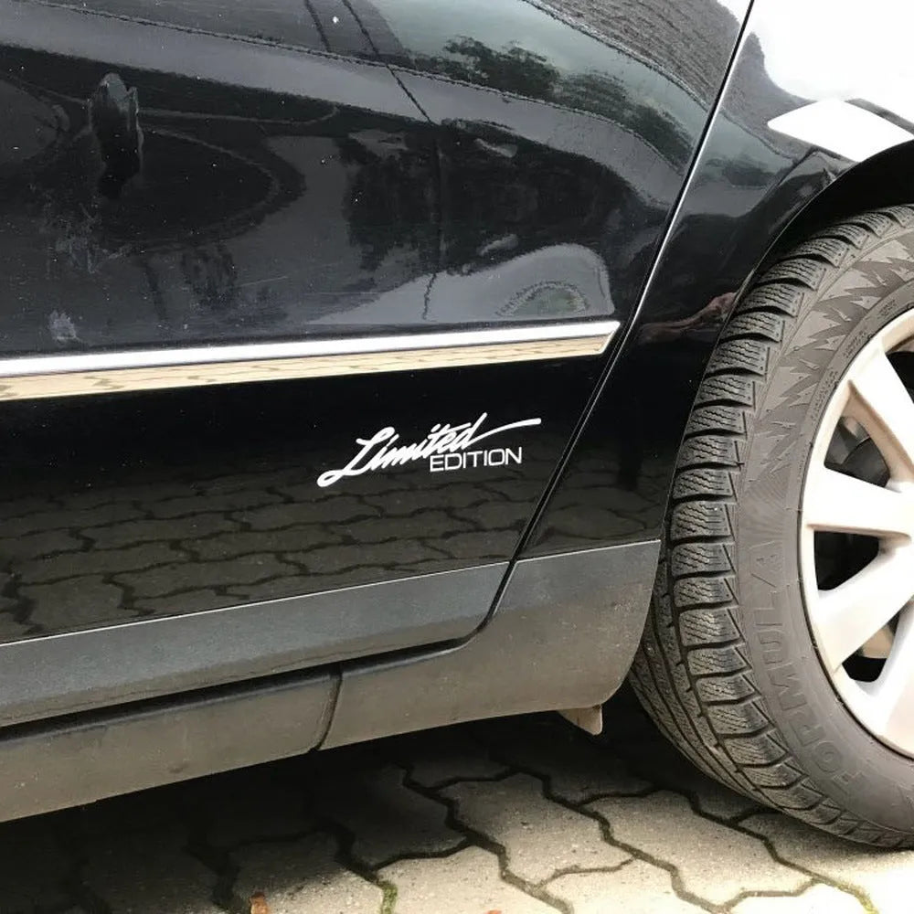 A black, white, and colourful British style reflective plastic bumper sticker, shown at its 16cm by 3.8cm size.