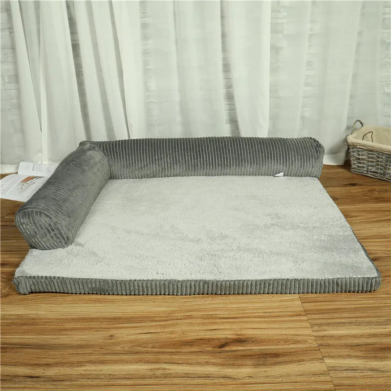 Grey corduroy dog sofa bed with raised sides and a non-slip base on a wooden floor.