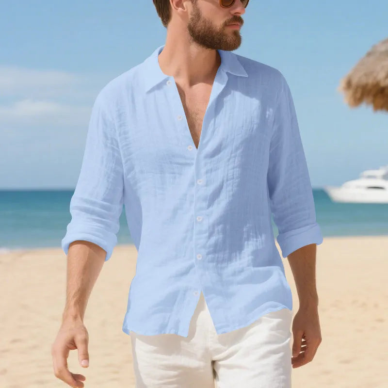 A man wearing a loose-fit light blue linen casual shirt with a non-iron finish, buttoned front and standard collar.