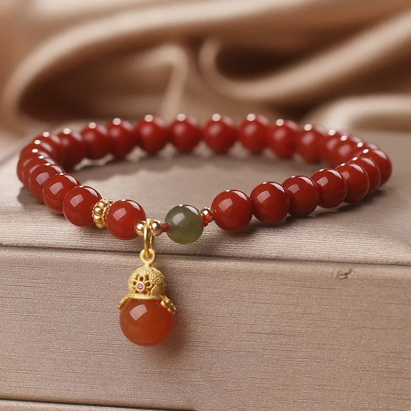 Red agate and Hetian jade bracelet with lucky beads pendant on display
