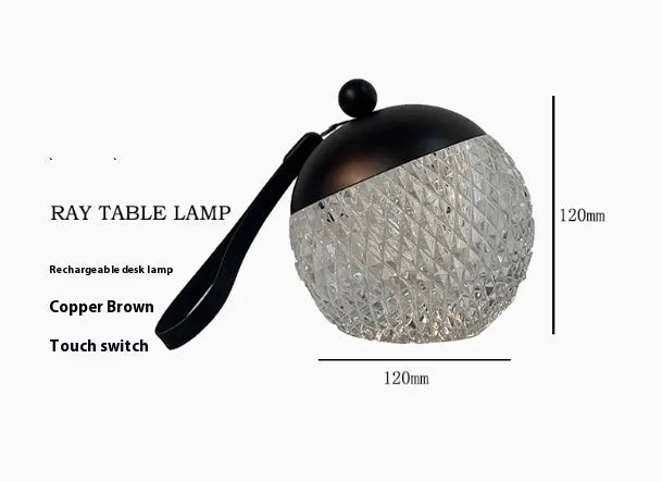 Small portable dimmable night lamp in chrome finish on wooden bedside table