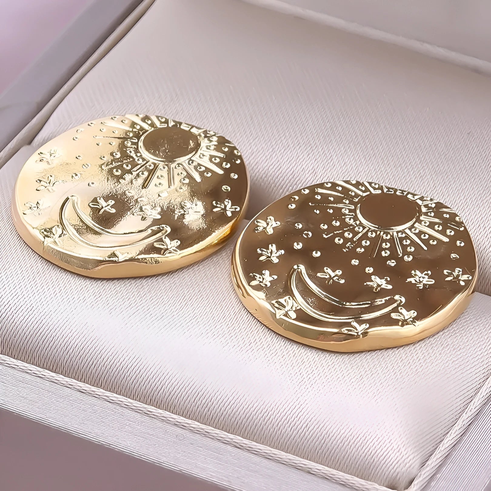 A pair of geometric stainless steel earring studs with a shell detail, shown in gold and silver colours.