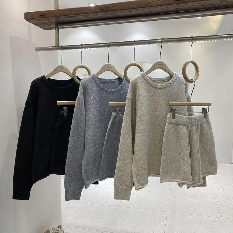 Women's loose grey acrylic knit sweater and wide-leg shorts set laid flat.