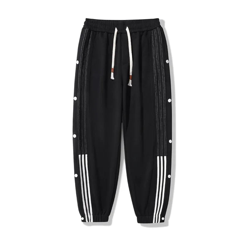 Men's black loose-fit ankle-tied sports trousers with high waist and drawstring closure on mannequin