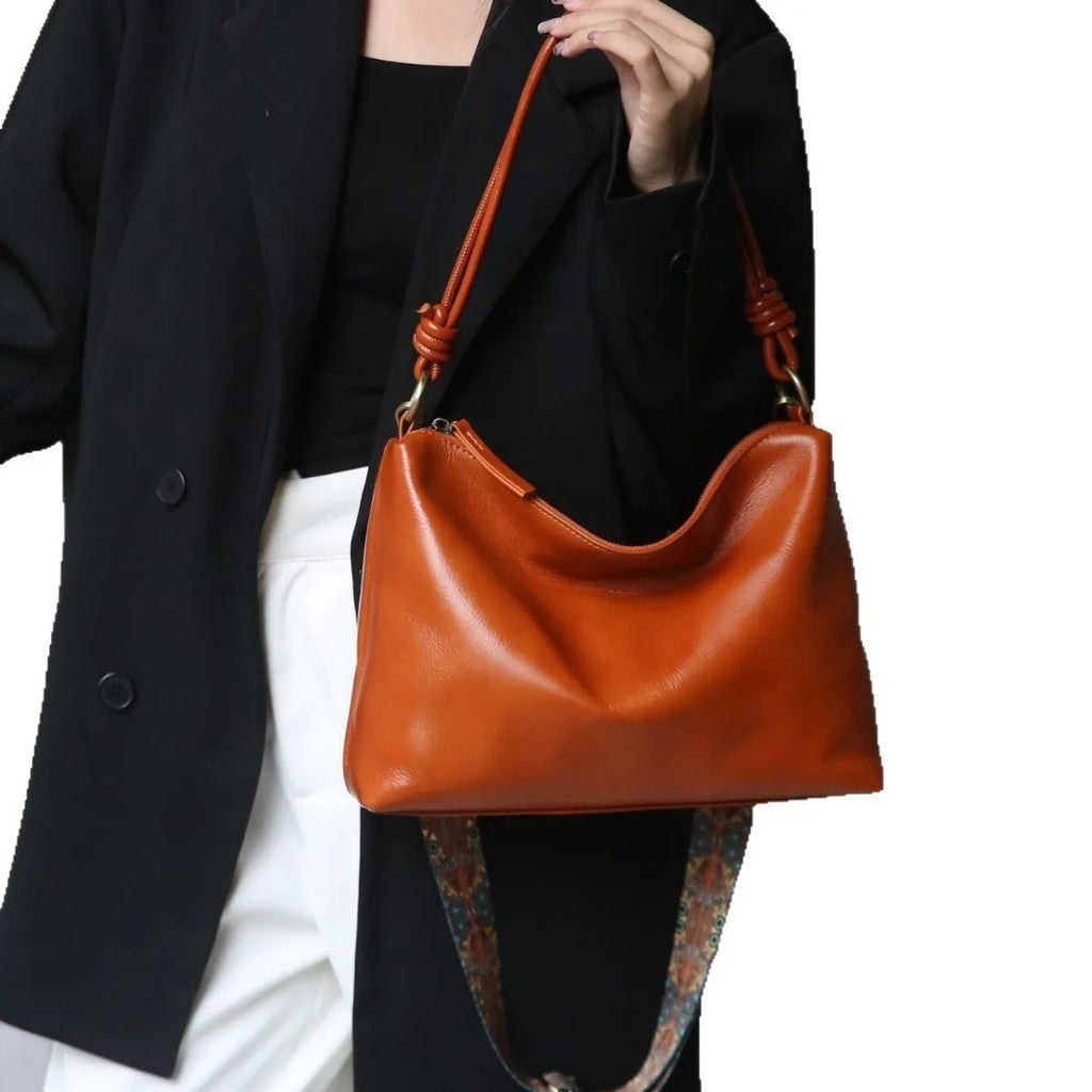 Genuine leather pillow-shaped commuter bag in caramel colour with double straps and patchwork detailing, 31x11x24cm
